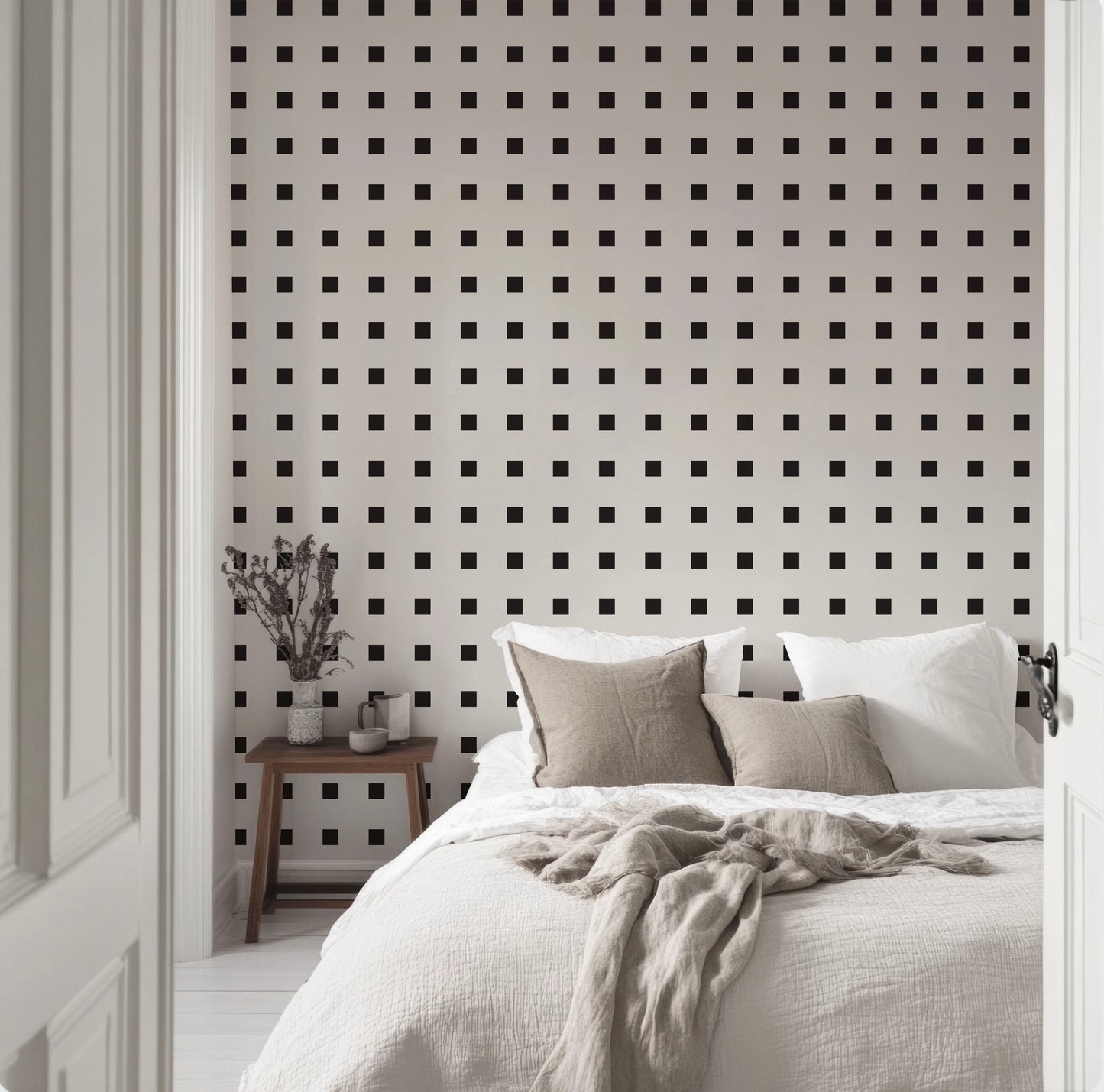 a bedroom with a white bed and black and white wallpaper