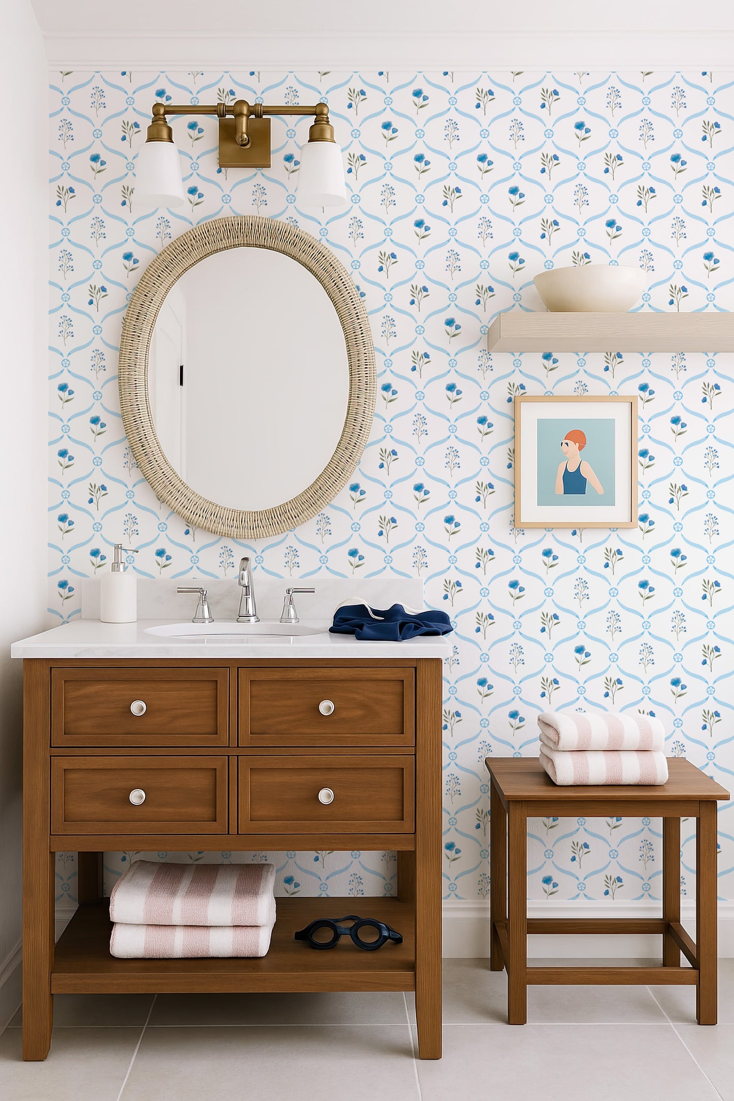 a bathroom with a wooden vanity, a round mirror, and a blue and white floral wallpaper. The vanity has a sink and a mirror above it, and there is a small stool next to the vanity.