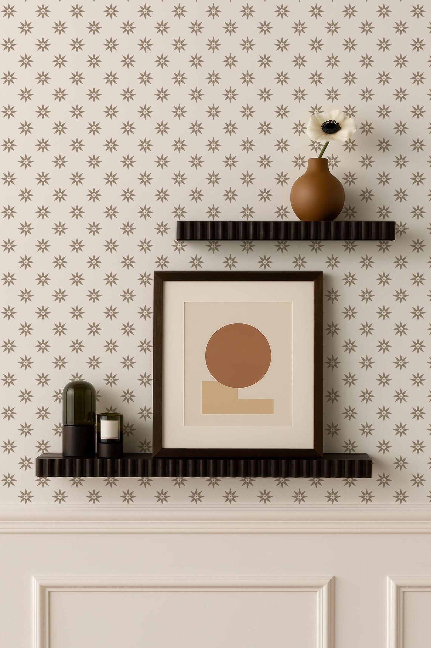 a wall with two dark brown shelves displaying various decorative items, including a framed picture, a vase with a flower, and a candle. The wall has a patterned wallpaper with small white stars.