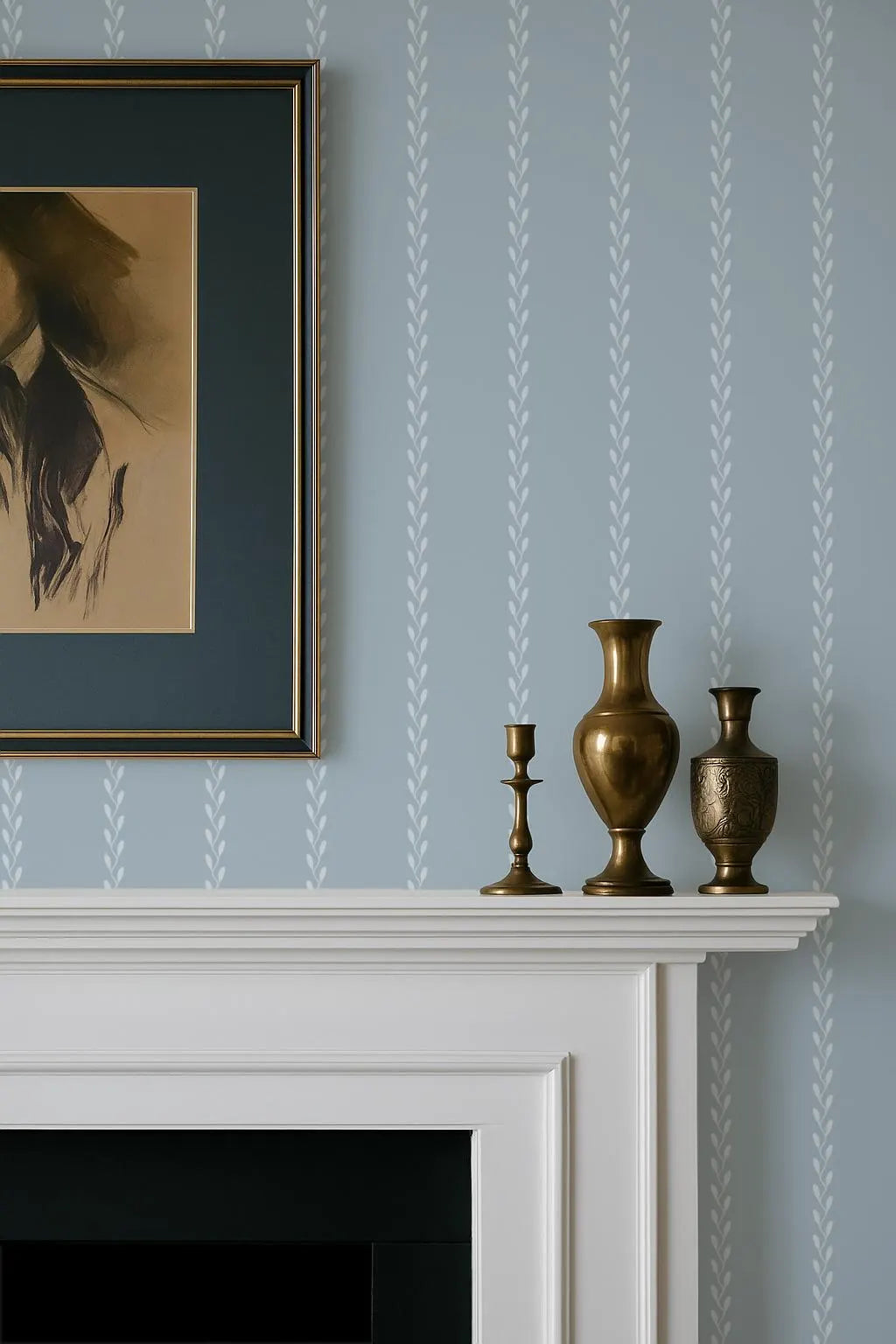 a white fireplace mantel with three decorative items on it, including a gold-colored vase, a candlestick, and a small statue. Above the mantel is a framed picture hanging on the wall.