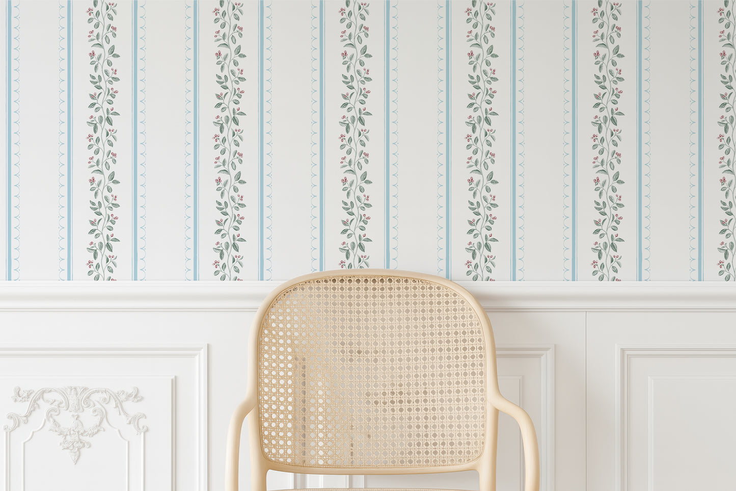 a cream-colored woven chair positioned against a wall with a decorative floral wallpaper.