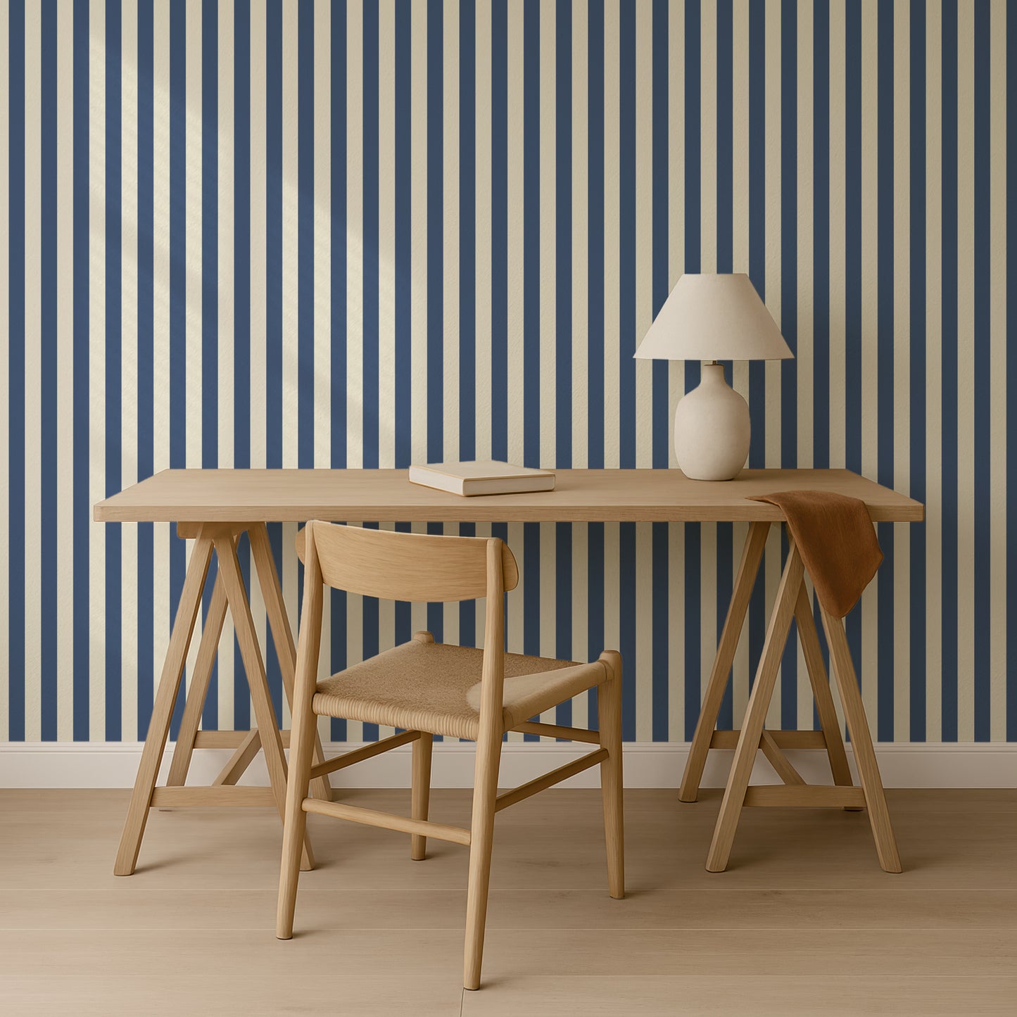 a wooden desk with a lamp and a chair, set against a striped blue and white wall.