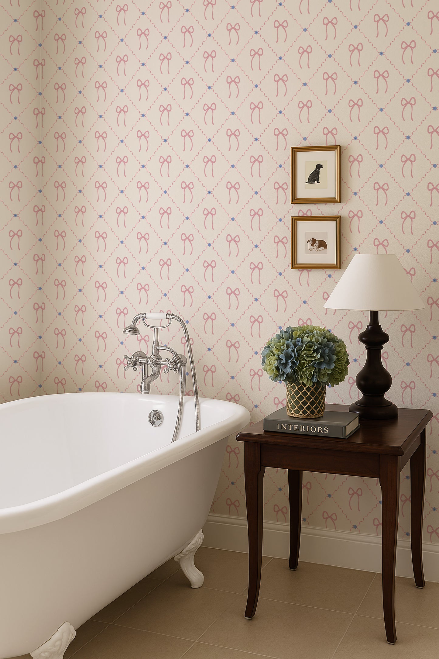 a bathroom with a clawfoot bathtub, a small side table with a lamp, and a framed picture on the wall. The walls are decorated with a pattern of pink bows, and there is a book on the side table.