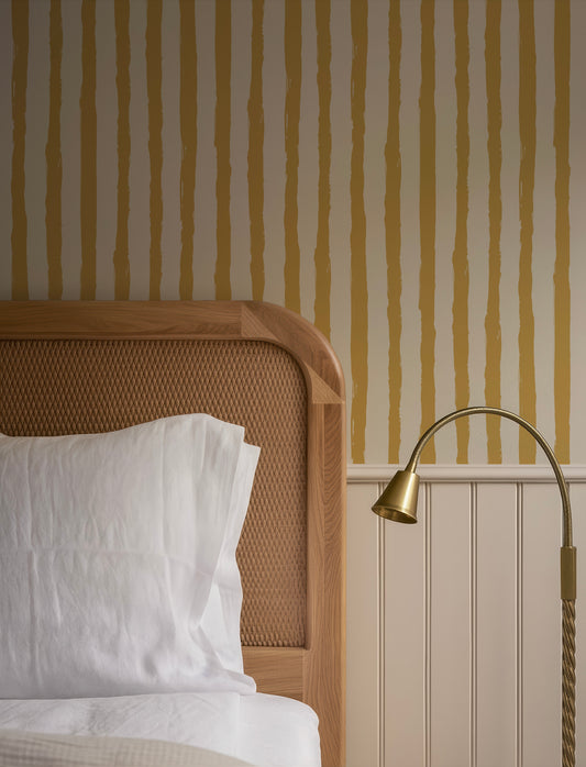a cozy bedroom scene with a wooden headboard, a white bedspread, and a lamp on a side table.