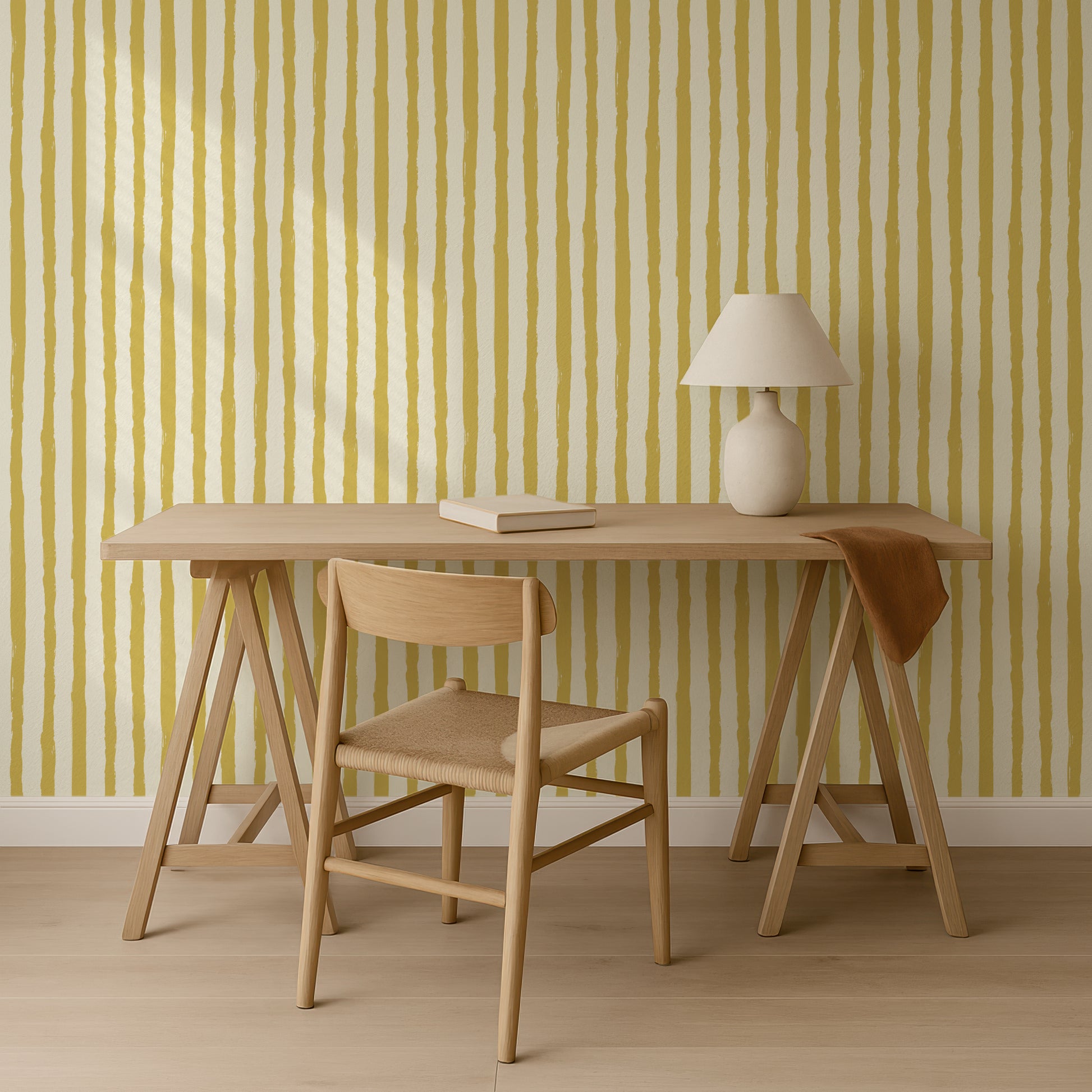 a wooden desk with a lamp and a chair, set against a striped yellow and white wall.