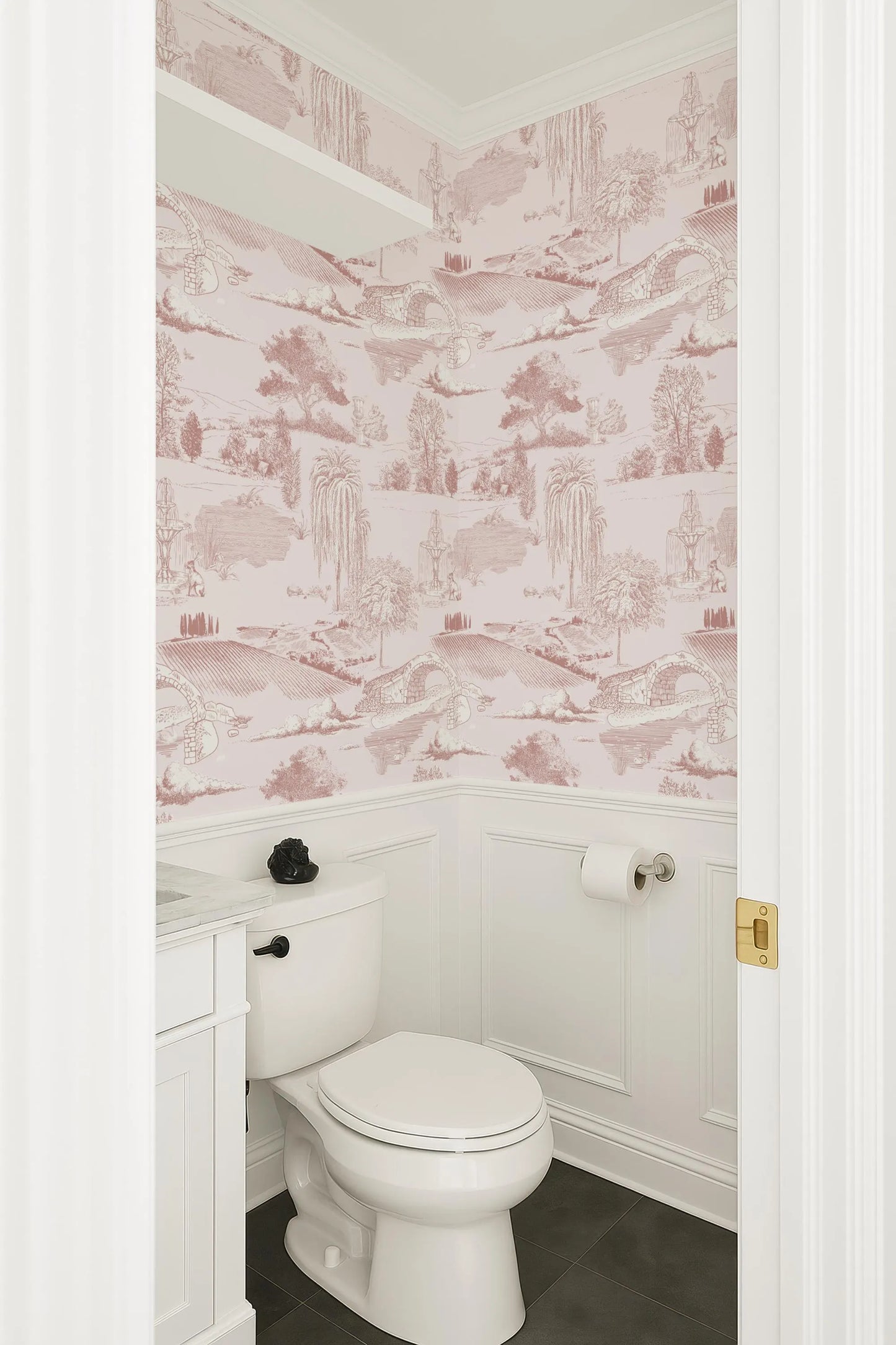 a bathroom with a white toilet and a pink and white wallpaper pattern on the walls.