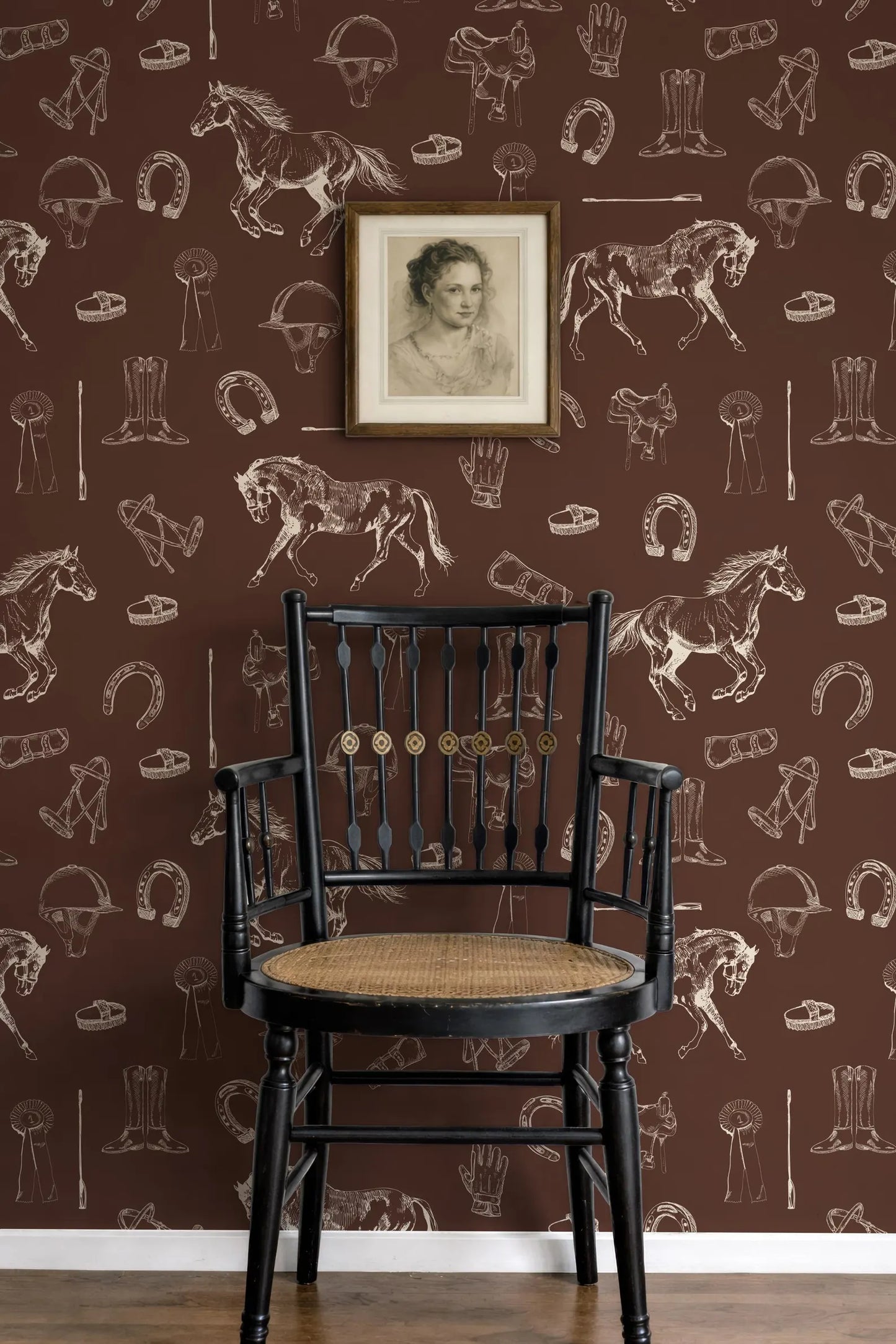 a black wooden chair with a woven seat, positioned against a brown wall with a repeating pattern of horse silhouettes and other horse-related objects. Above the chair, there is a framed portrait of a woman.