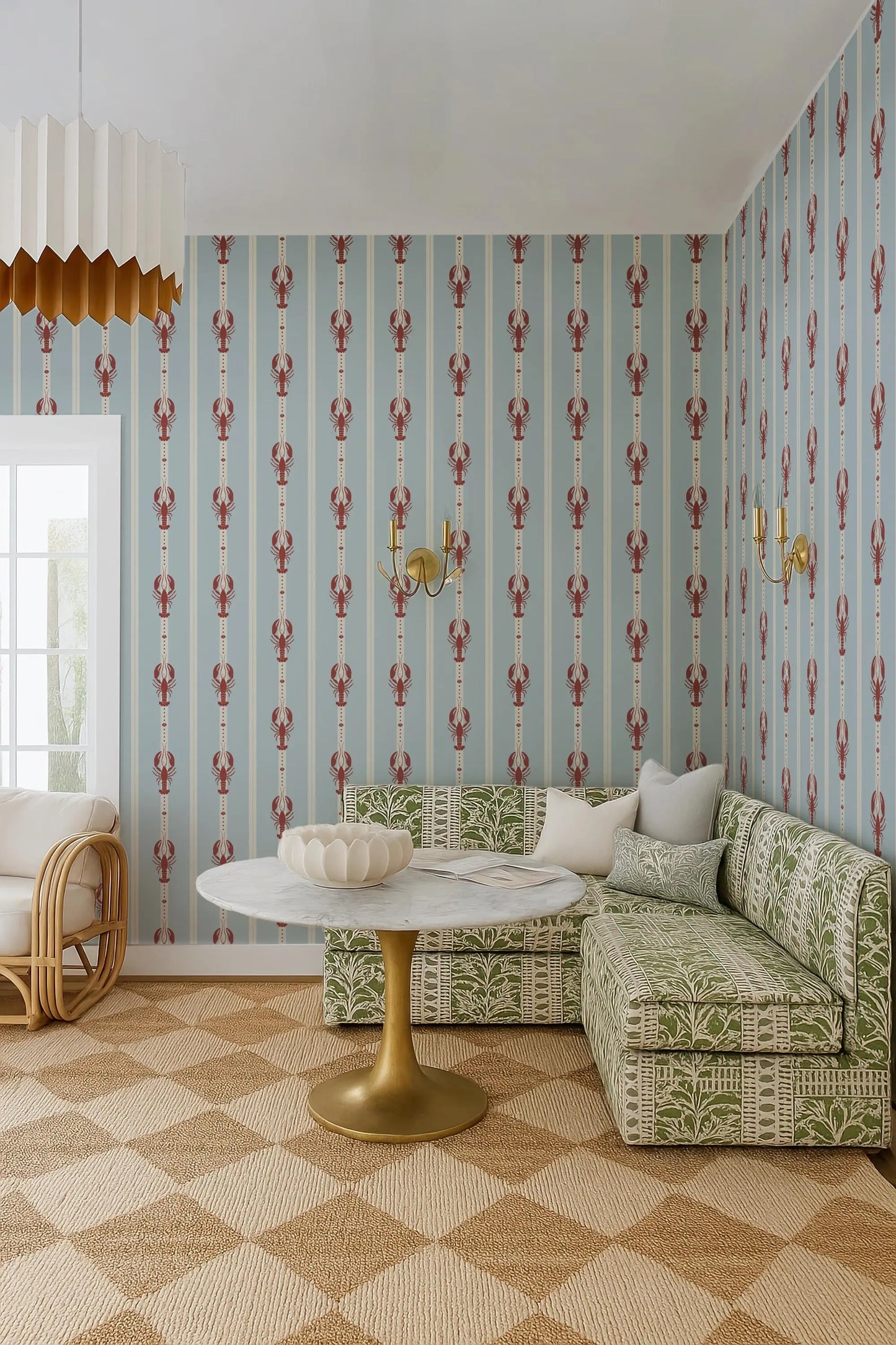 a cozy living room with a green and white patterned sofa, a round white table with a gold base, and a patterned rug on the floor. The walls are covered in a blue and white striped wallpaper with red lobster motifs.