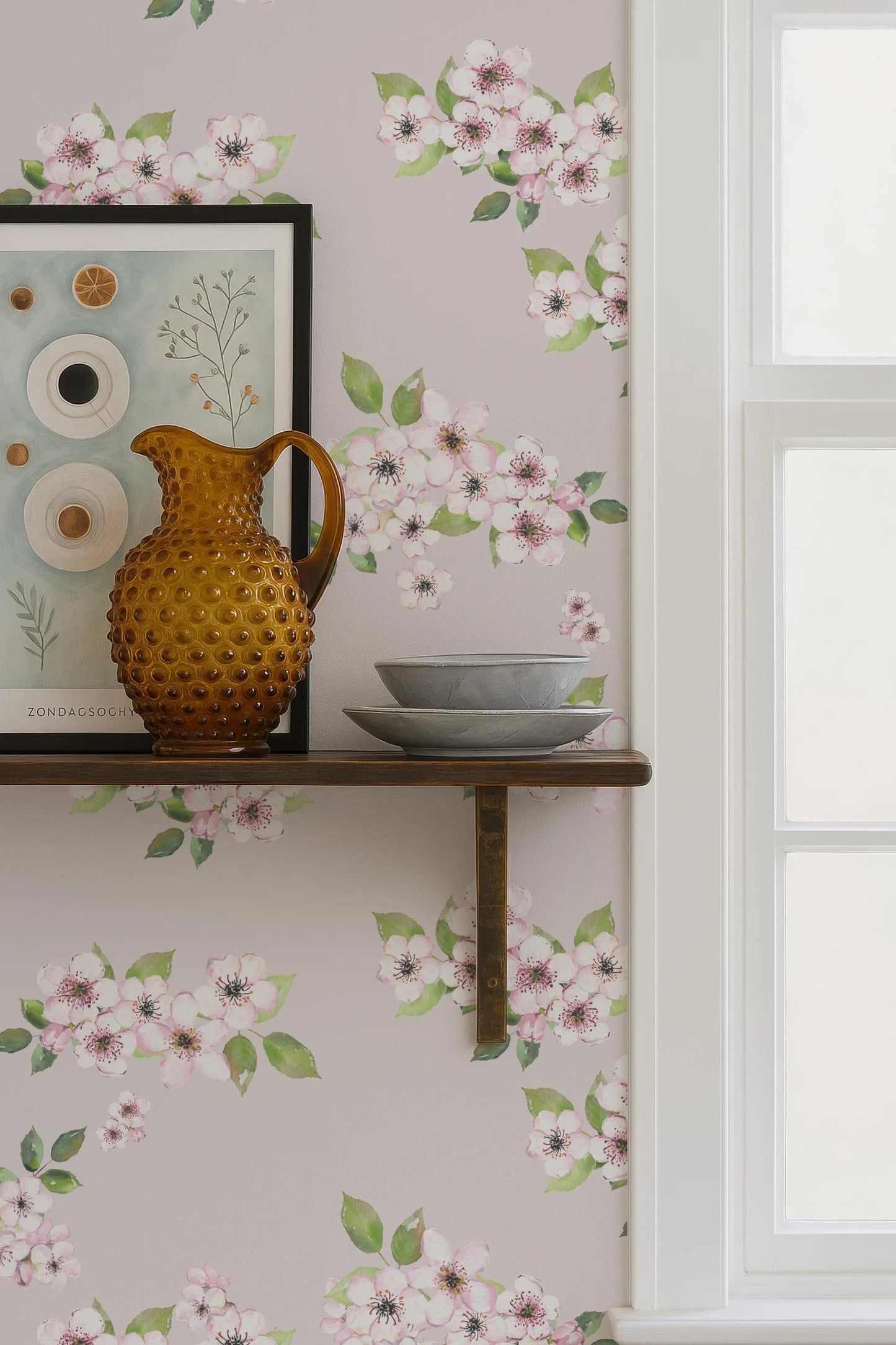 a shelf with a brown vase, a bowl, and a picture frame, set against a wall with a floral wallpaper.