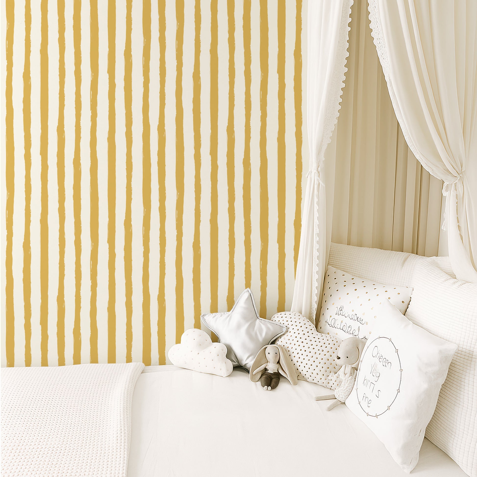 A cozy and inviting bedroom scene with a white canopy bed, a striped wallpaper, and various decorative pillows and stuffed animals.