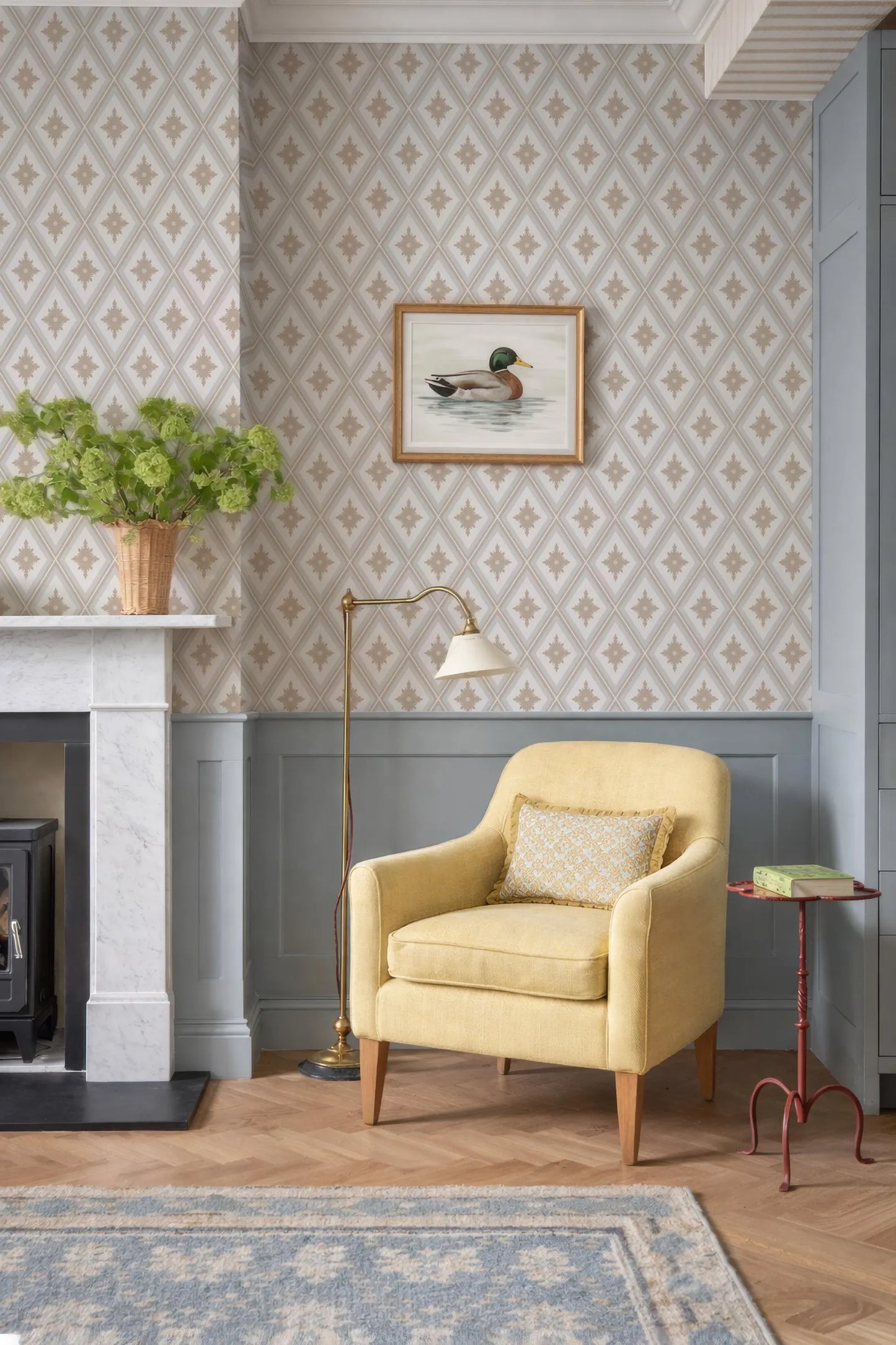 a cozy living room with a yellow armchair, a fireplace, a framed picture of a duck, and a potted plant.