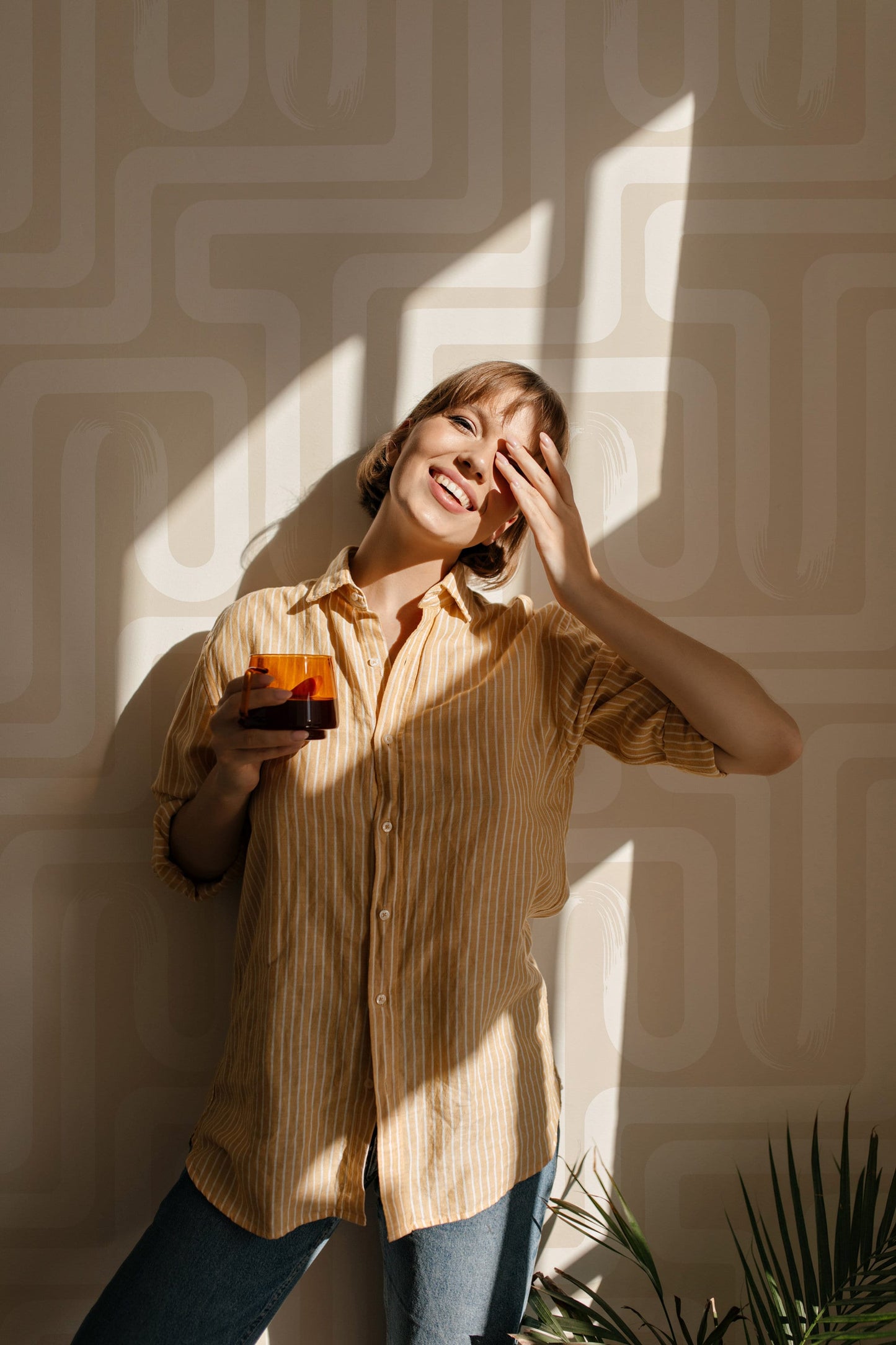 a woman holding a glass of orange juice