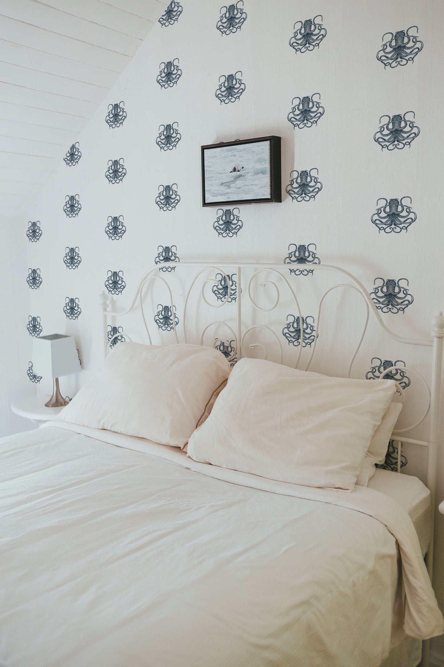 a white bed with a white comforter and pillows