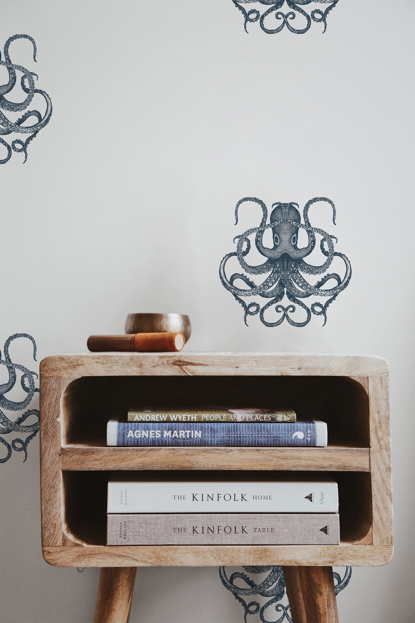 a wooden table topped with books next to a wall