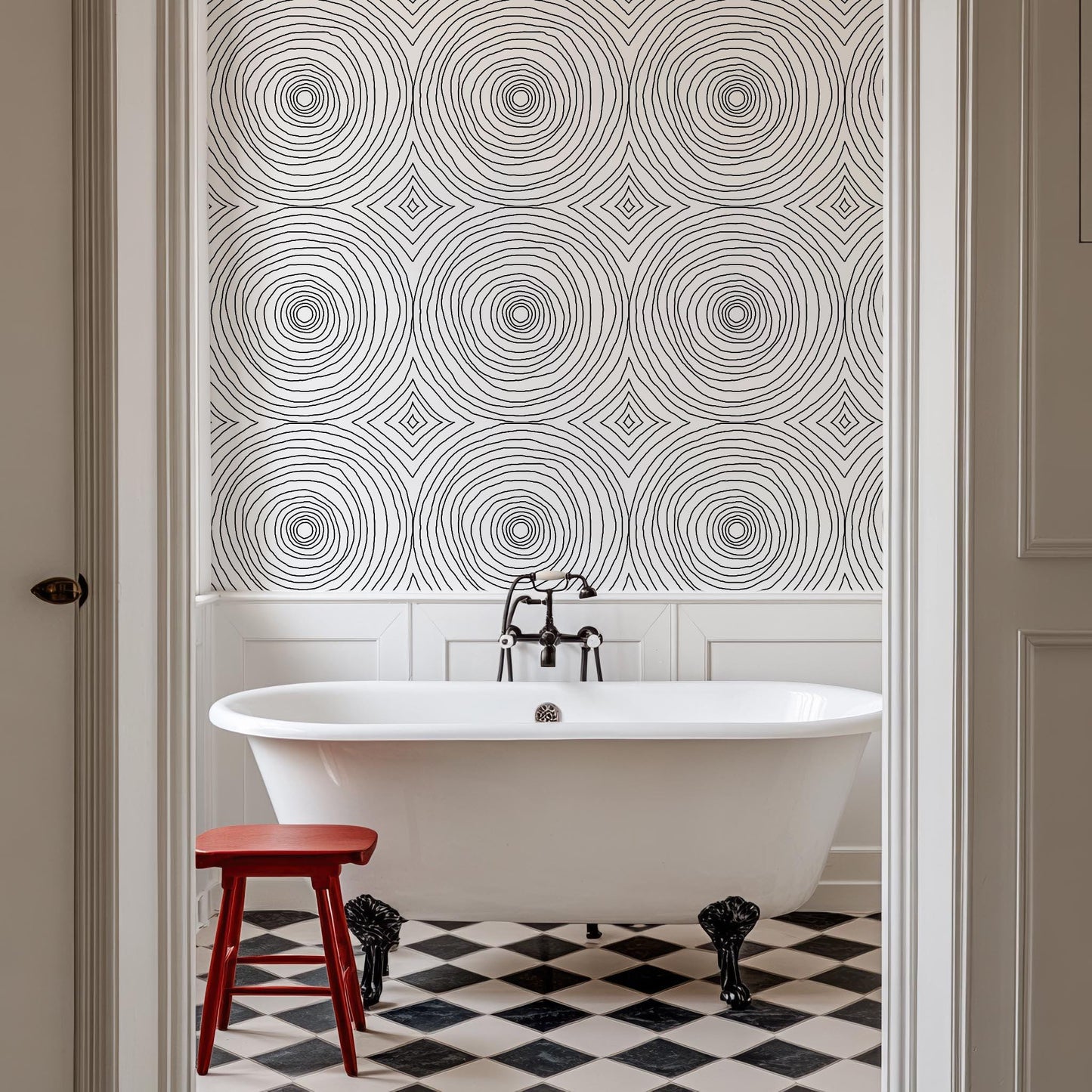 a white bath tub sitting next to a red stool