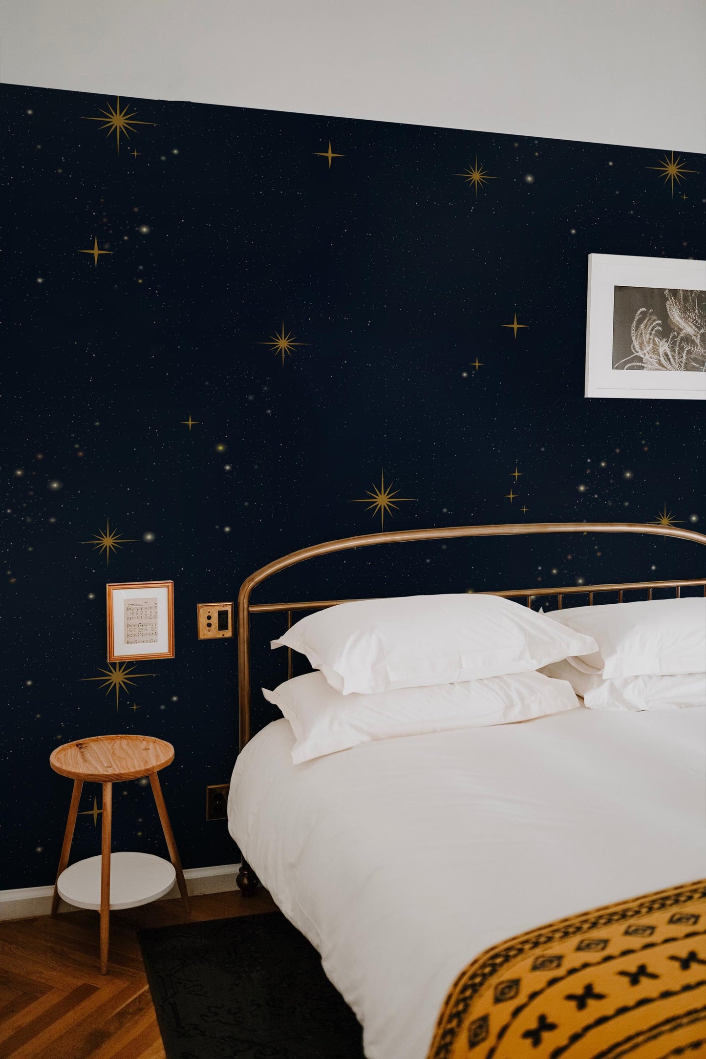 a bedroom with a bed and a night sky wallpaper