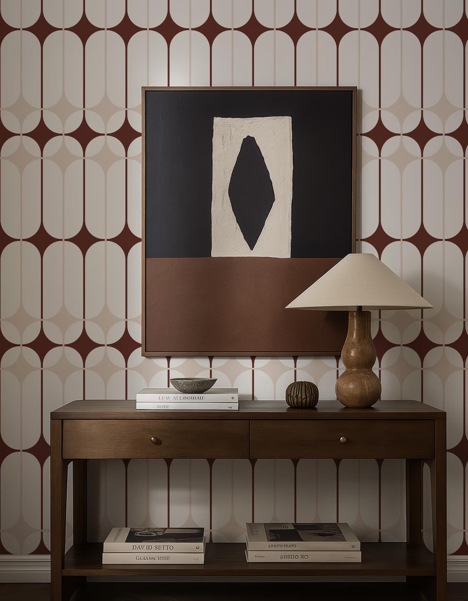 a wooden console table with a lamp, books, and a framed abstract artwork on the wall above it.