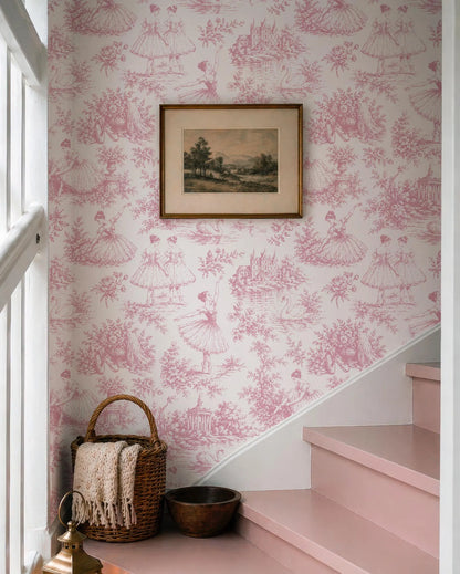 a pink and white wallpaper with a framed picture hanging on the wall above a wicker basket and a small bowl.
