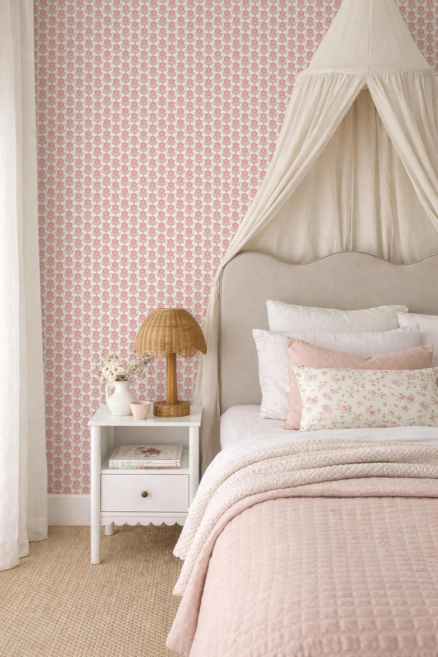 a cozy and inviting bedroom with a canopy bed, a white nightstand, and a pink and white floral wallpaper.