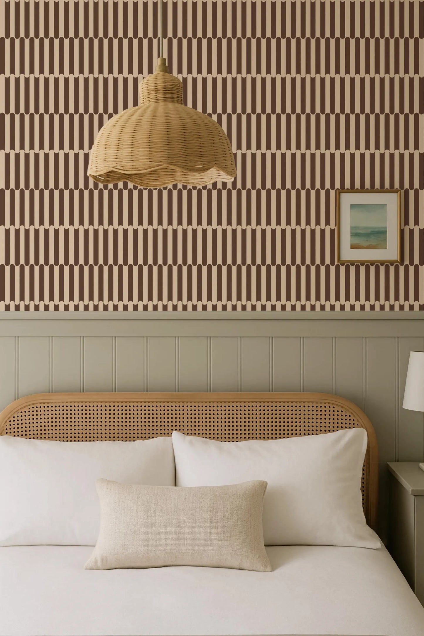 a cozy bedroom with a bed, a wicker pendant lamp, and a framed picture on the wall.