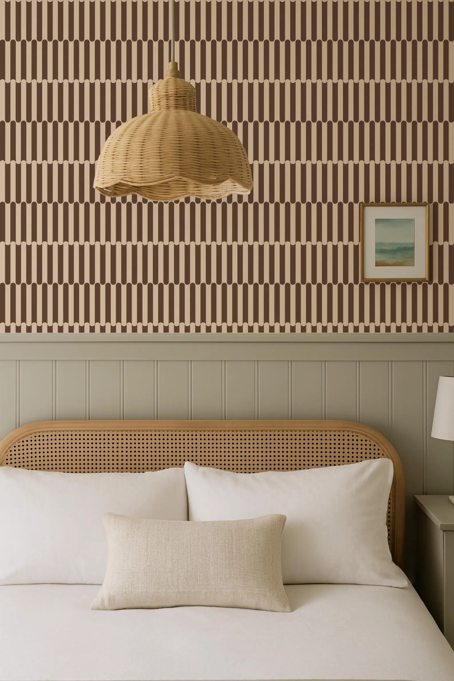 a cozy bedroom with a bed, a wicker pendant lamp, and a framed picture on the wall.