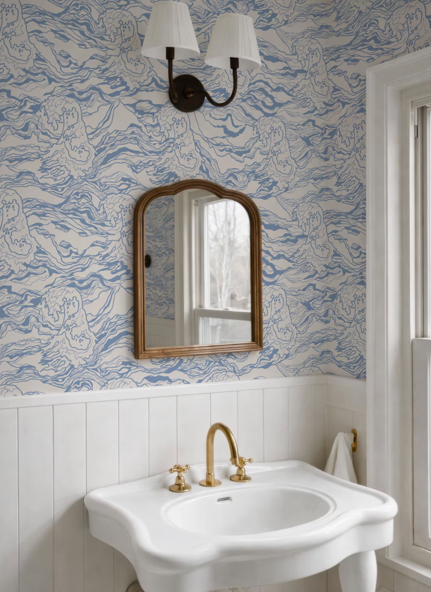 a bathroom with a white sink, a mirror, and a light fixture above it. The walls are covered in a blue and white wallpaper with a wave pattern.