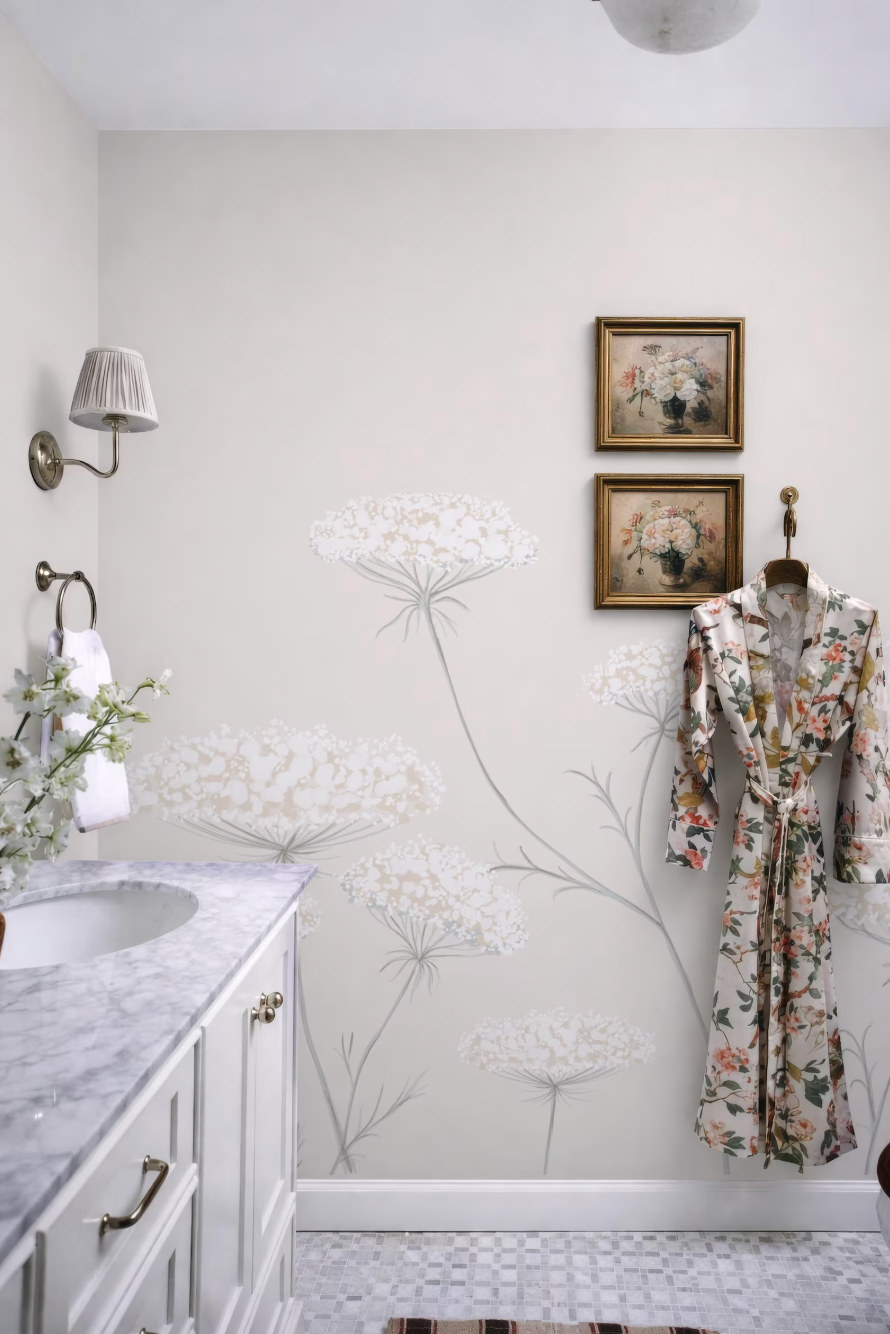 a bathroom with a floral pattern on the wall, a white sink, and a framed artwork above the sink.