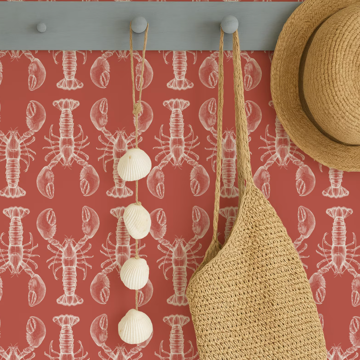 a wall with a red and white pattern, including a lobster and a straw hat, as well as a woven straw bag hanging on a hook.