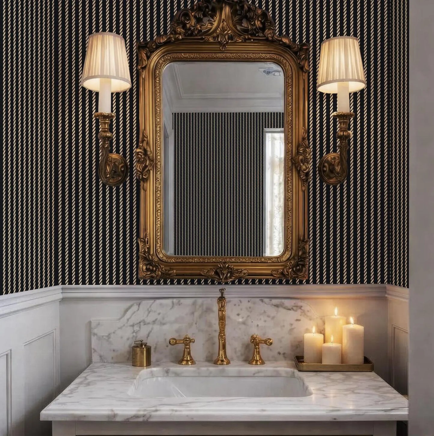 a luxurious bathroom with a marble vanity, a gold-framed mirror, and two wall sconces with white shades. The bathroom has a black and white striped wallpaper, and there are three lit candles on the vanity.