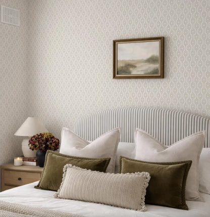 a well-decorated bedroom with a bed, a framed landscape painting on the wall, and a lamp on a nightstand.