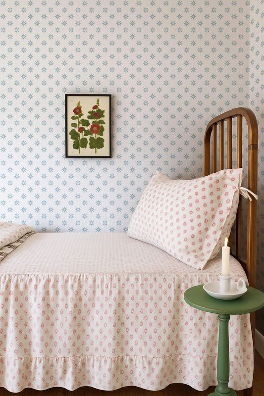 a cozy bedroom scene with a bed, a nightstand, and a framed floral print on the wall.