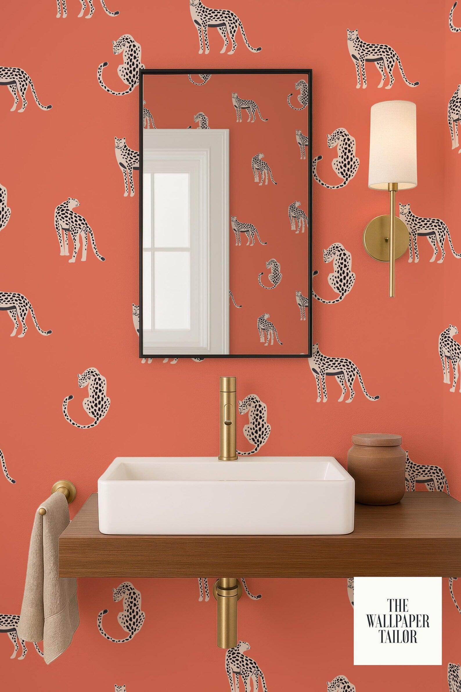 a bathroom with a white sink and a mirror, set against a vibrant orange wall with a repeating pattern of leopard-like animals.