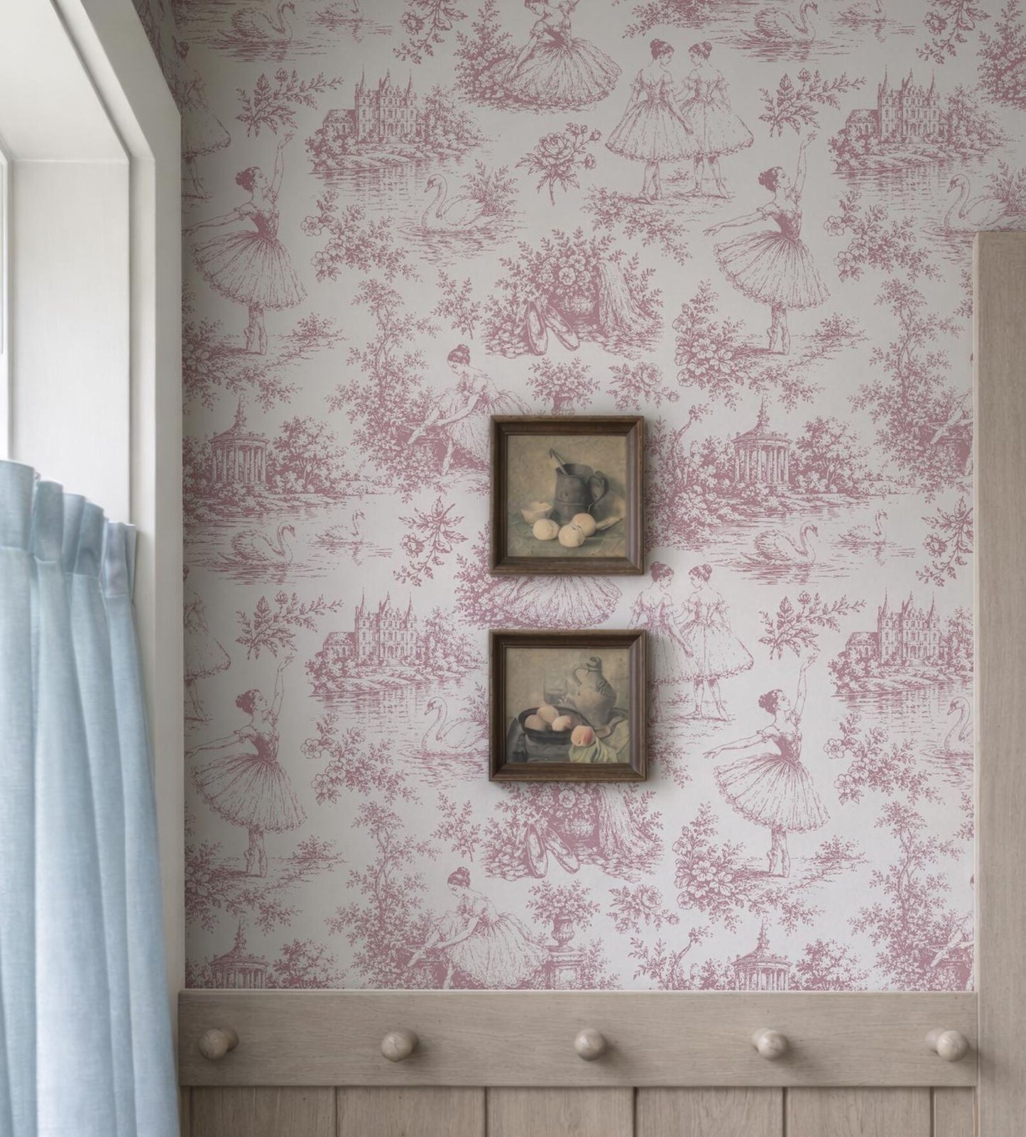 a wall with a pink and white wallpaper pattern, and two framed pictures hanging on it.