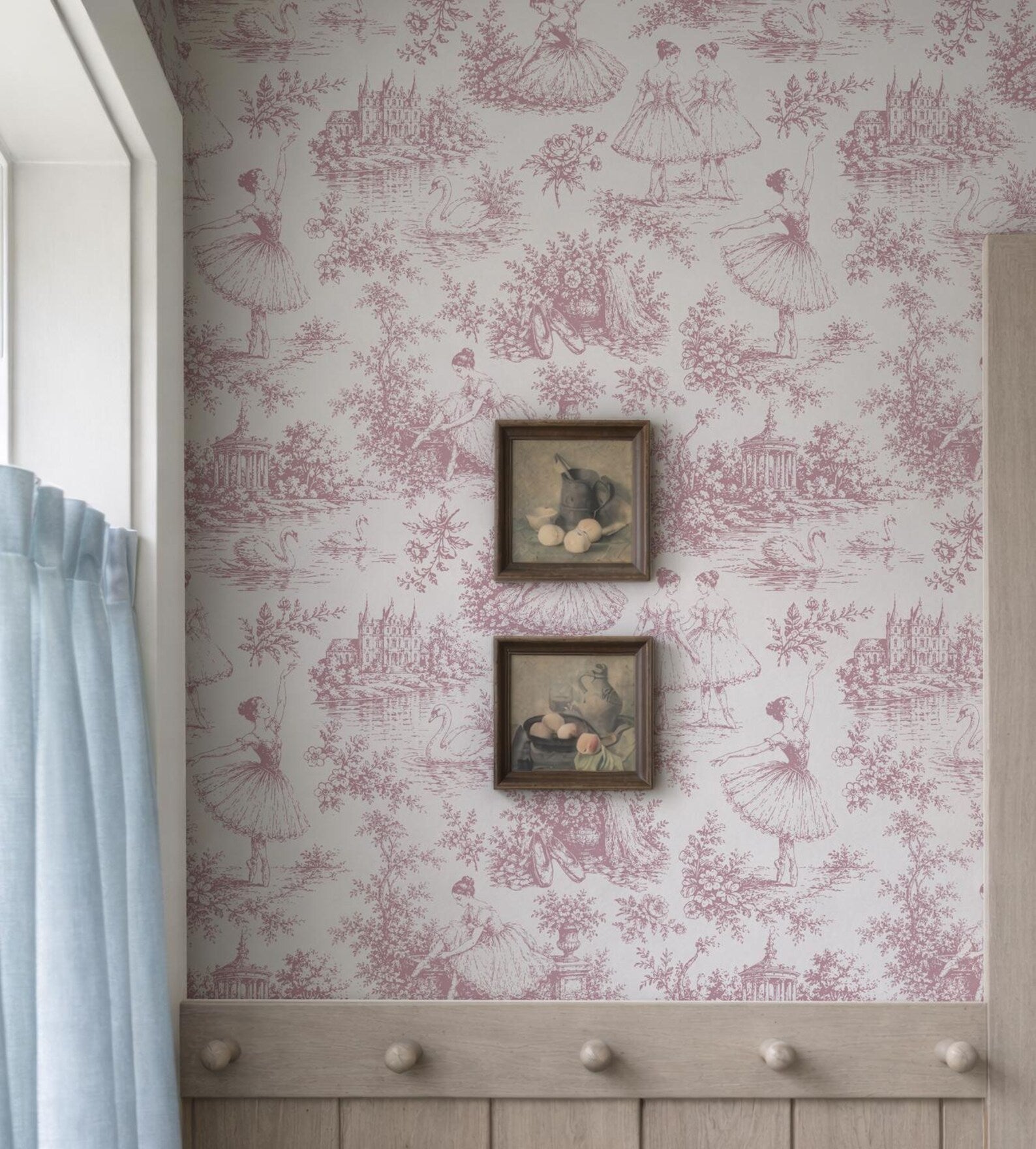 a wall with a pink and white wallpaper pattern, and two framed pictures hanging on it.