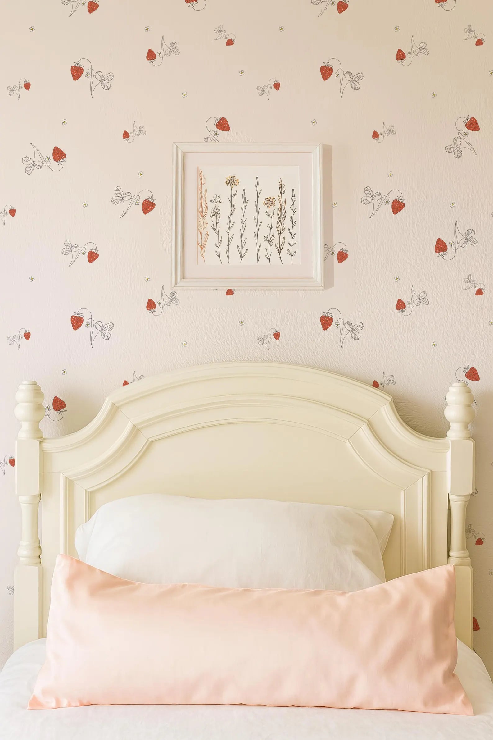 a bedroom with a white wooden headboard and a framed print of flowers on the wall above it. The bed has a white pillow and a pink pillow, creating a cozy and inviting atmosphere.