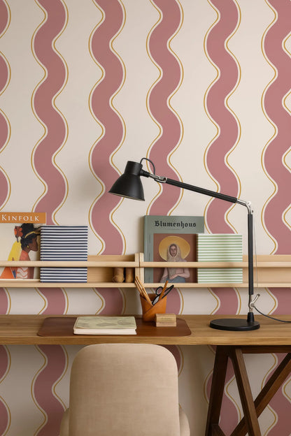 a wooden desk with a lamp, a book, and a magazine, set against a wall with a patterned wallpaper.