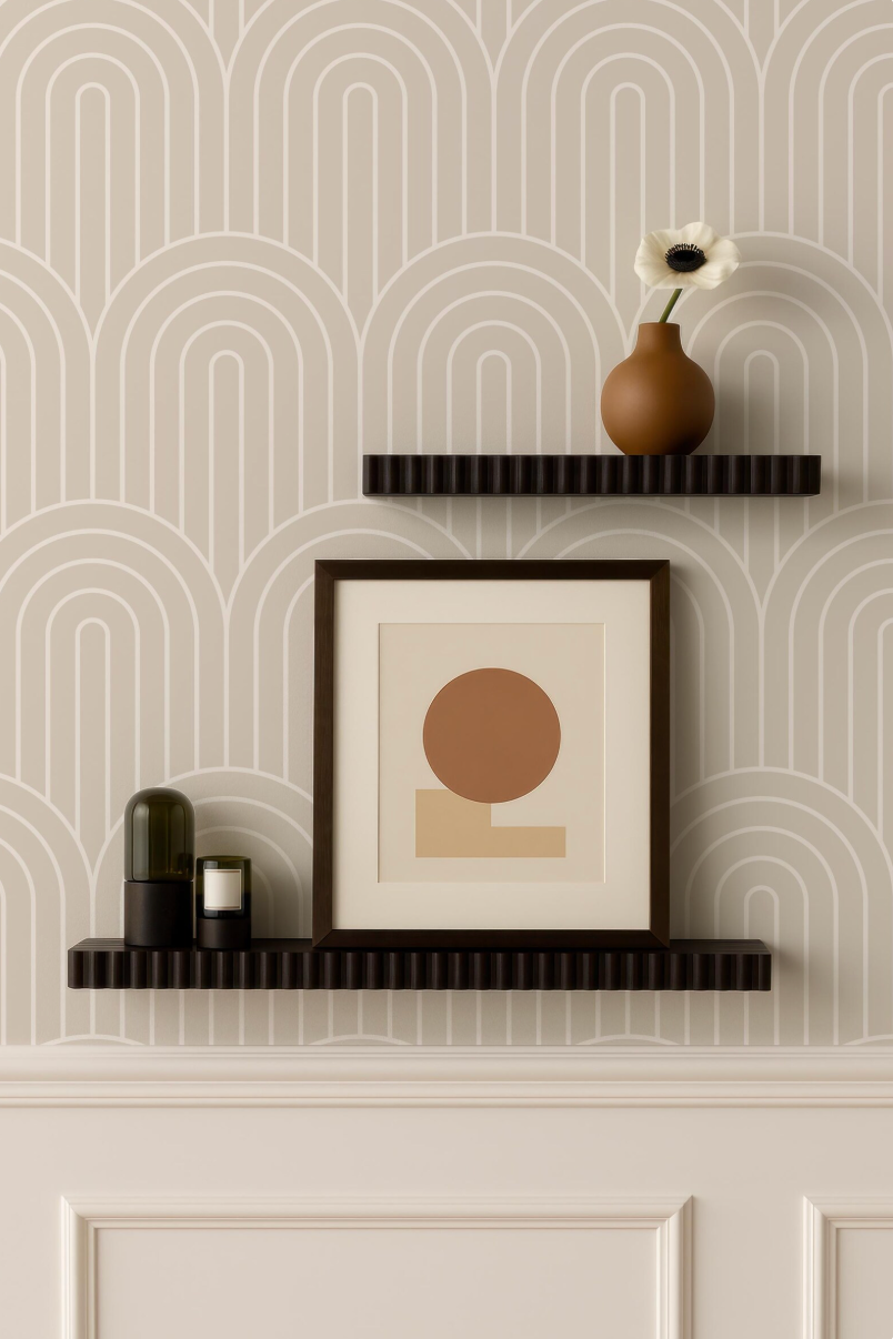a minimalist interior design with a wallpapered wall, two black floating shelves, and a framed artwork. The artwork displays a circular design, and a vase with a white flower is placed on one of the shelves.