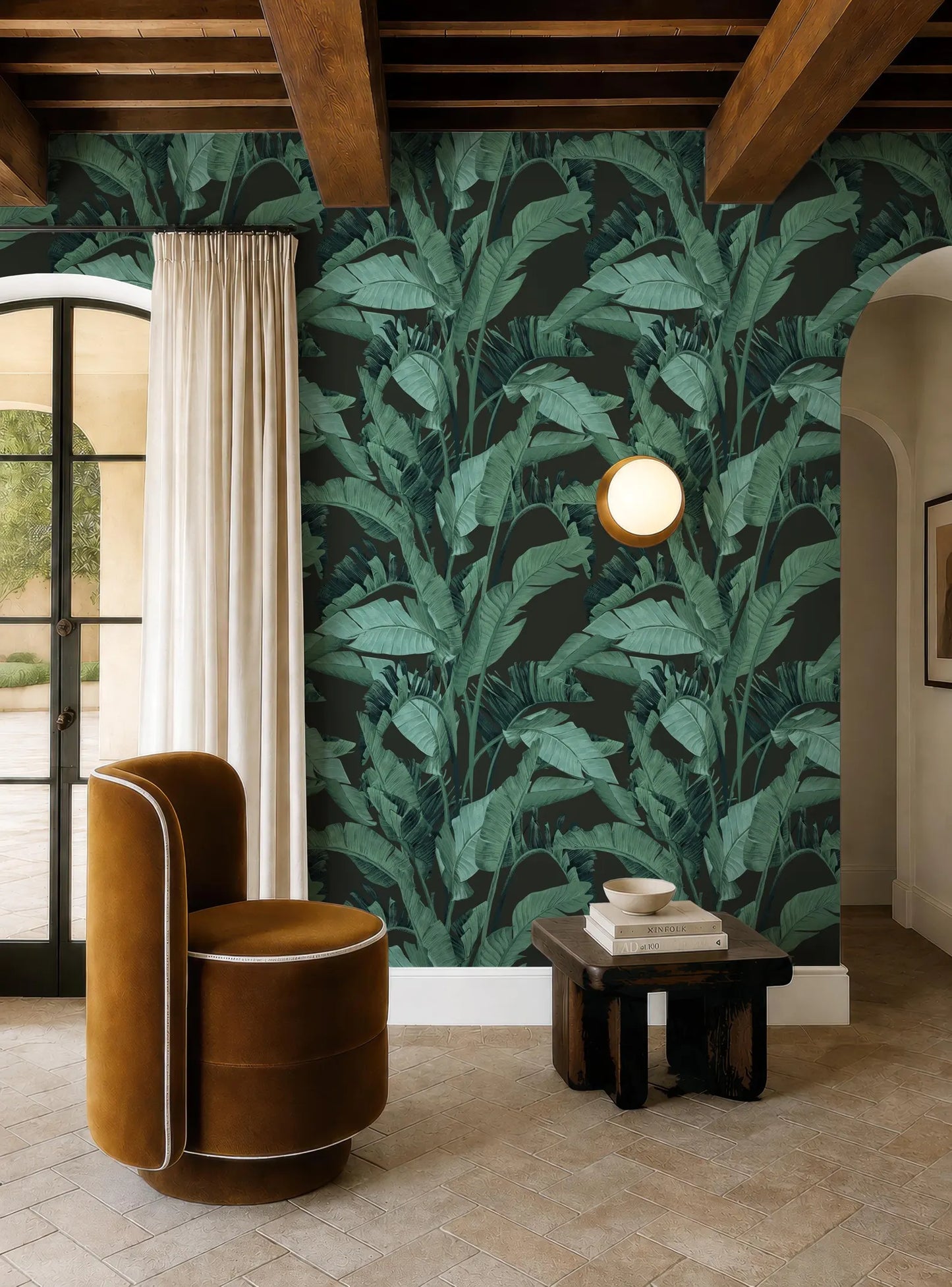 a living room with a large green wallpapered wall, a brown armchair, a wooden side table, and a round light fixture.