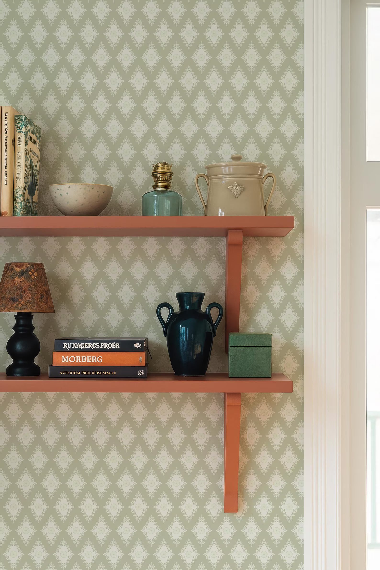 a wooden shelf with various decorative items and books, including a blue vase, a white bowl, a green vase, a black lamp, and a stack of books.