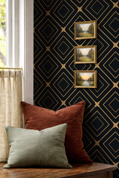 a cozy corner with a wooden table, a window with white curtains, and a black and gold diamond patterned wallpaper. Three framed landscape paintings are hung on the wall above the table, creating a visually appealing and harmonious space.