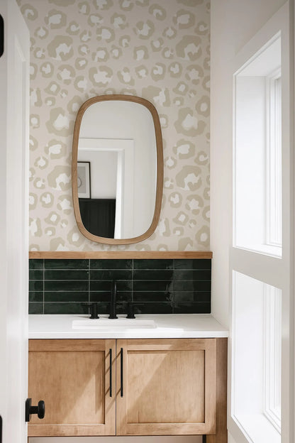 a bathroom with a white and beige leopard print wallpaper, a wooden vanity with a white countertop, and a black faucet above the countertop.