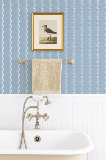 a bathroom with a clawfoot bathtub, a towel rack, and a framed painting of a bird on the wall.