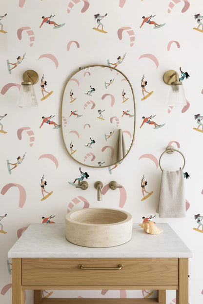 a bathroom with a white sink, a mirror, and a towel rack. The wall behind the sink has a pattern of surfers riding waves.