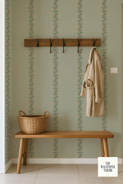 a wooden bench with a wicker basket on it, placed against a wall with a patterned wallpaper. A coat is hanging on a wooden coat rack above the bench.