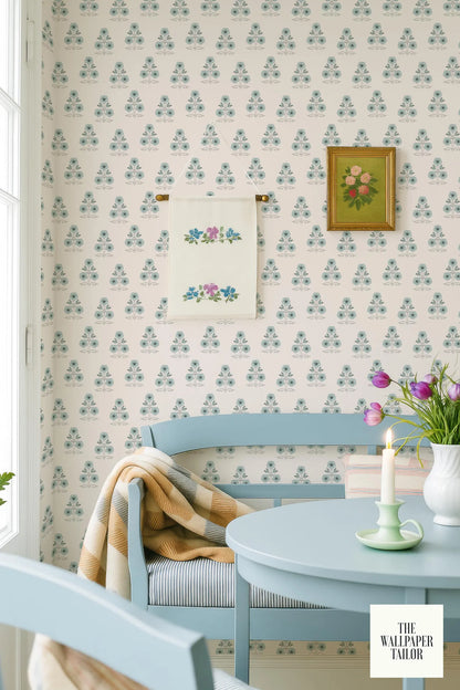 a cozy and charming dining area with a blue bench, a table with a candle, and a framed floral print on the wall.