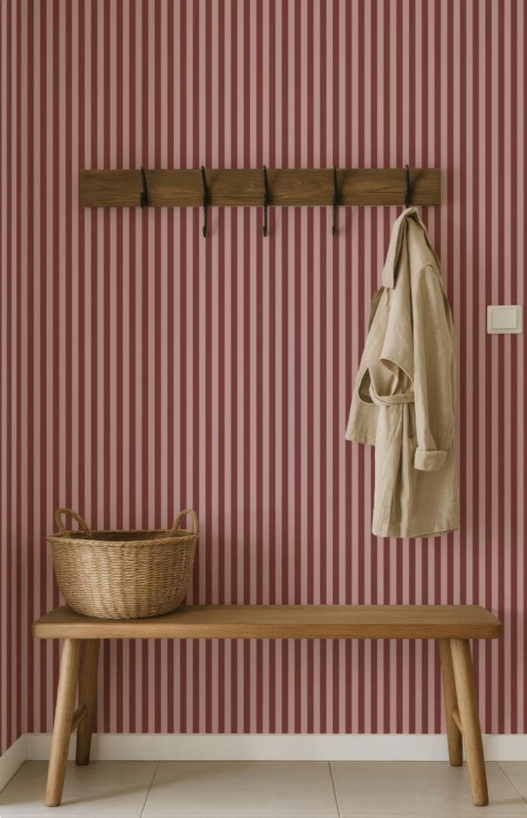 a wooden bench with a wicker basket on top, set against a striped pink and white wall.