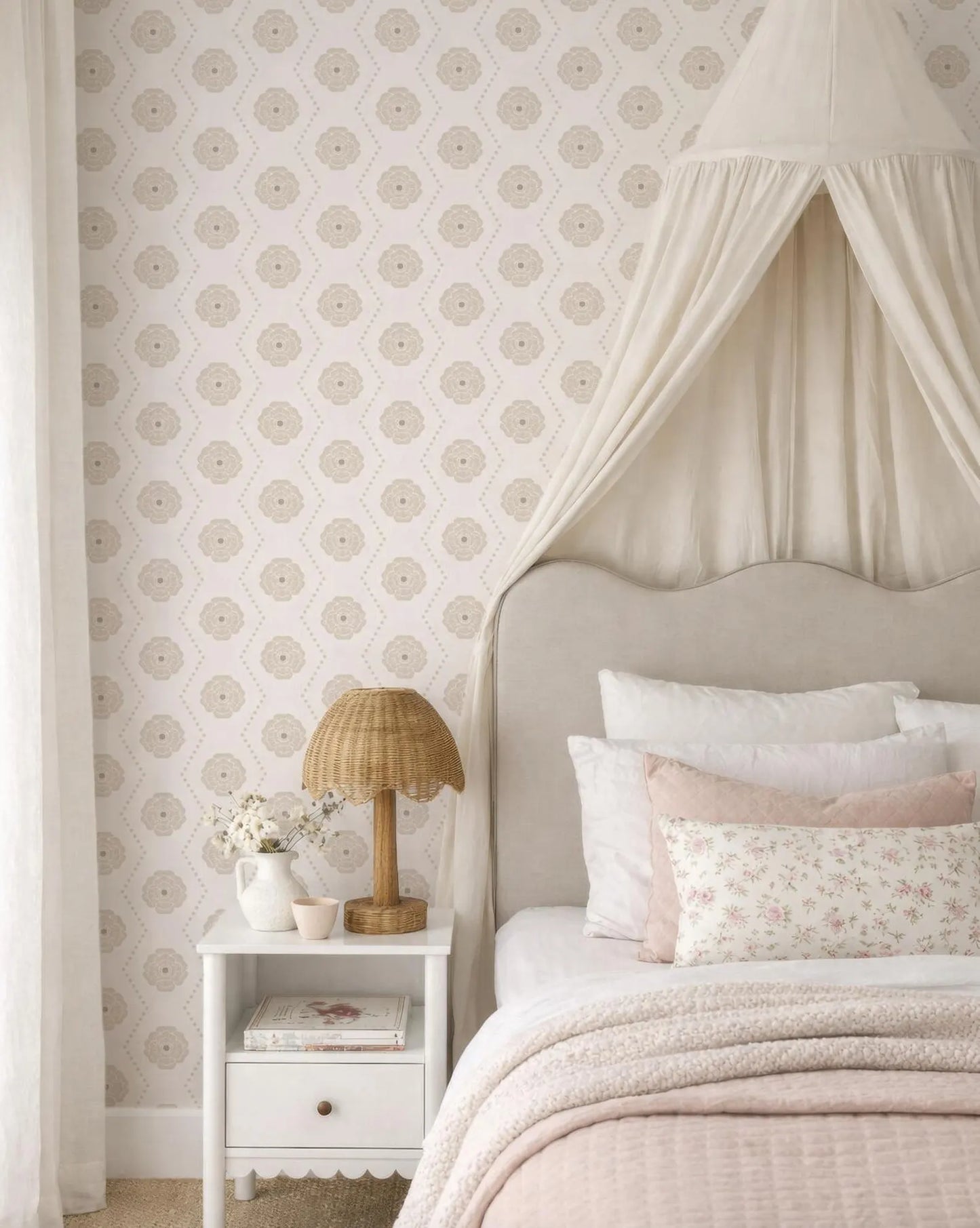 a cozy and inviting bedroom with a canopy bed, a white nightstand, and a floral patterned wallpaper.