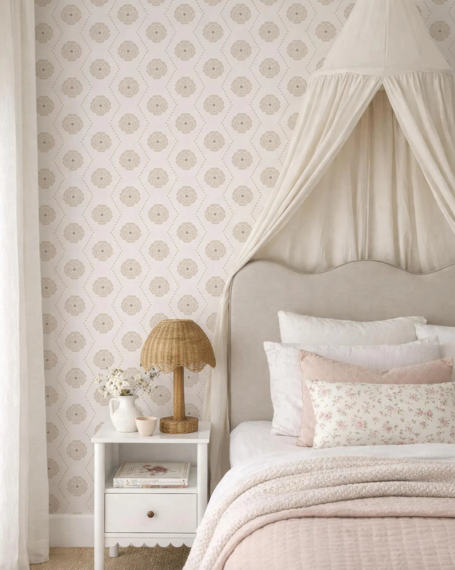 a cozy and inviting bedroom with a canopy bed, a white nightstand, and a floral patterned wallpaper.