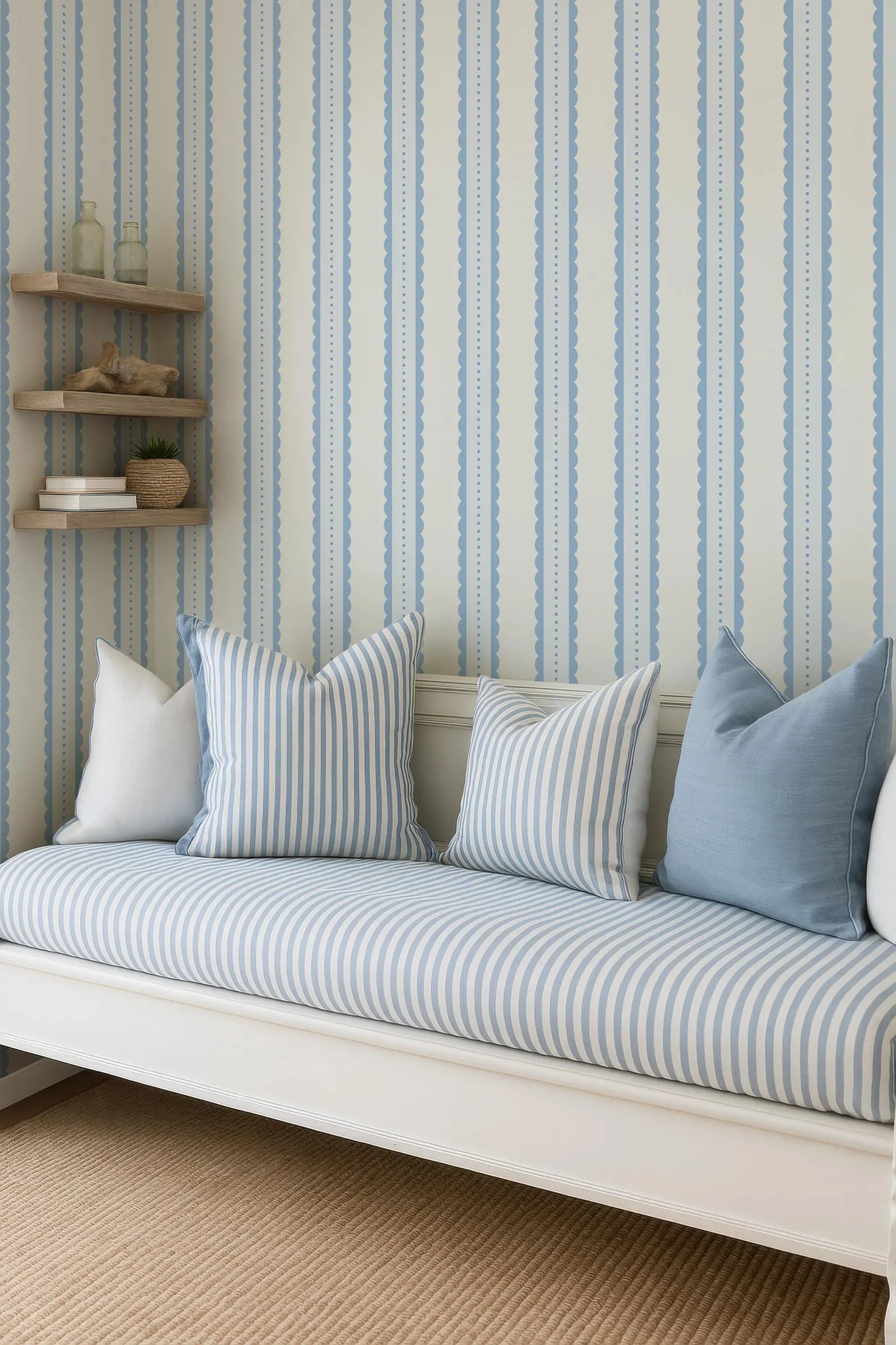 a cozy living room with a white sofa adorned with blue and white striped pillows. The sofa is positioned against a wall with blue and white striped wallpaper, creating a harmonious and inviting atmosphere.