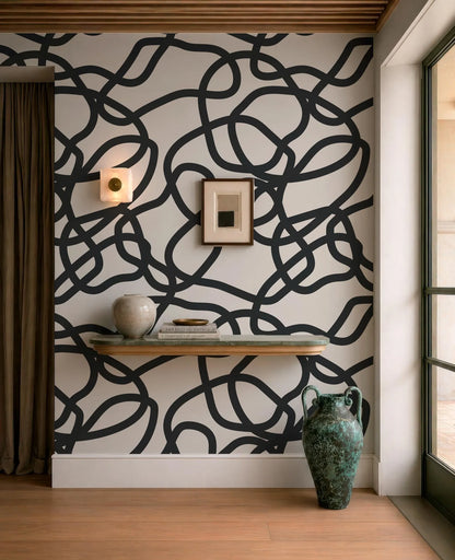a modern interior design with a black and white abstract pattern on the wall behind a wooden shelf. On the shelf, there is a vase and a book, adding a touch of elegance to the space. The room also includes a window and a door, providing natural light and access to the outside.